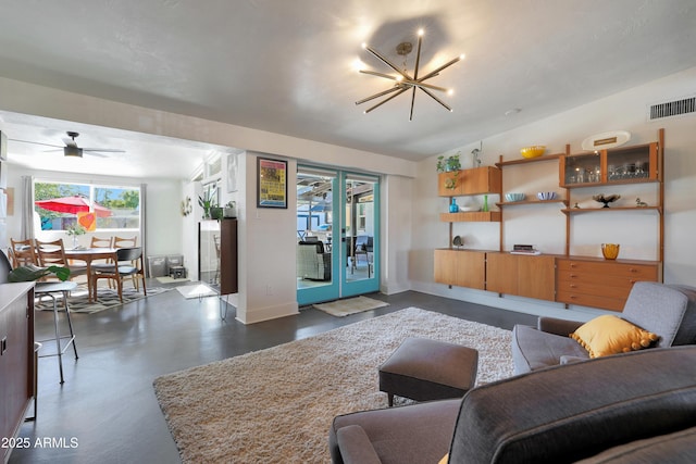 living room with ceiling fan with notable chandelier