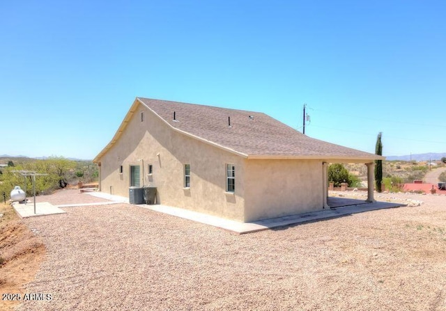 rear view of property featuring a patio and central air condition unit