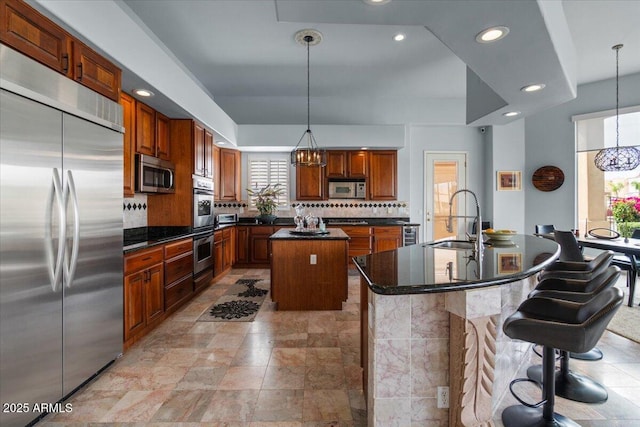 2128 E Clipper Ln, Gilbert, AZ 85234 - kitchen featuring stainless steel appliances, a kitchen island with sink, a sink, dark countertops, and decorative backsplash