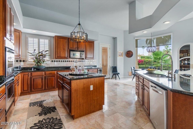 2128 E Clipper Ln, Gilbert, AZ 85234 - kitchen featuring a kitchen island with sink, a sink, a chandelier, stainless steel appliances, and backsplash