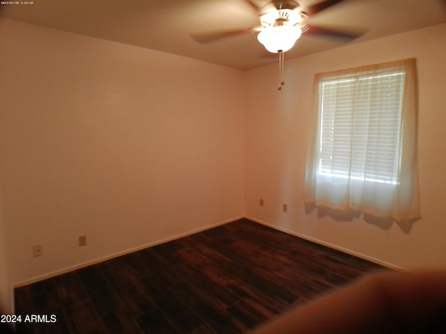 empty room with ceiling fan and dark wood-type flooring