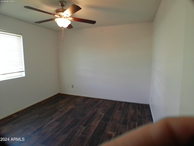 unfurnished room with ceiling fan and dark wood-type flooring