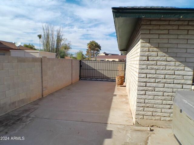 view of gate featuring a patio