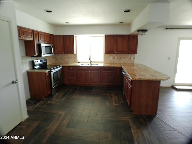 kitchen featuring kitchen peninsula, stainless steel appliances, a wealth of natural light, and sink