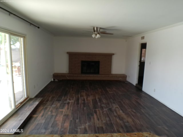 unfurnished living room with ceiling fan, a fireplace, dark hardwood / wood-style floors, and ornamental molding