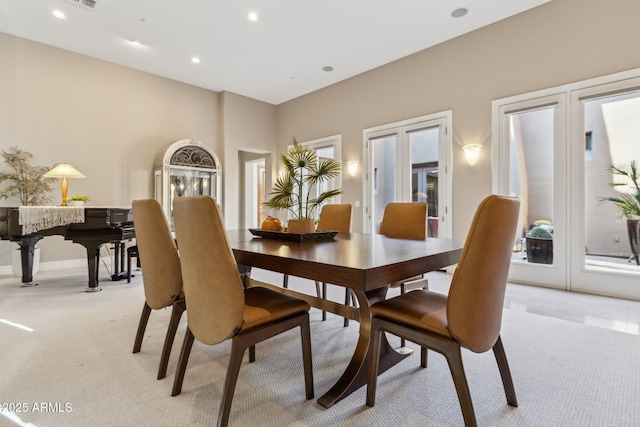 dining room with french doors and light colored carpet