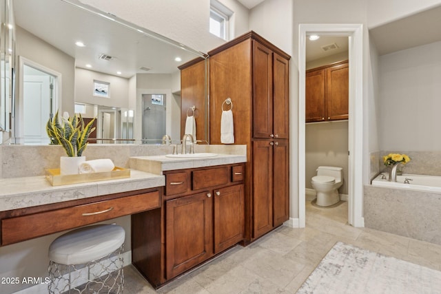 bathroom with vanity, toilet, and tiled tub