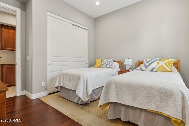 bedroom with dark hardwood / wood-style floors and a closet