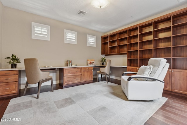 office area with built in desk and light wood-type flooring