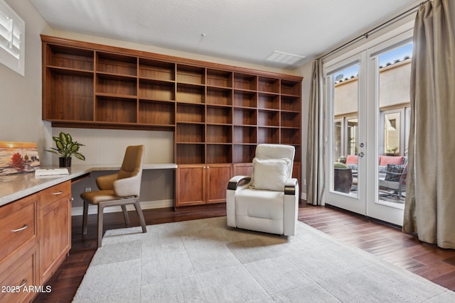 living area featuring french doors, wood-type flooring, and built in desk