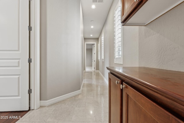 hallway with light tile patterned flooring and plenty of natural light