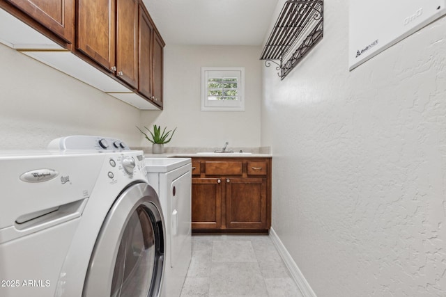 clothes washing area with light tile patterned flooring, cabinets, separate washer and dryer, and sink