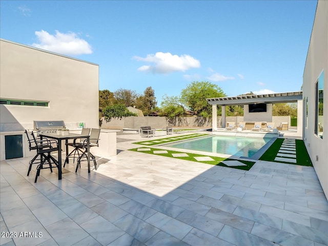 view of swimming pool with a patio, a fenced backyard, a fireplace, a fenced in pool, and an outdoor kitchen