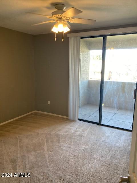 carpeted empty room featuring ceiling fan