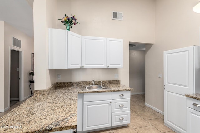 511 E Purdue Ave, Phoenix, AZ 85020 - kitchen featuring a sink, white cabinetry, baseboards, light tile patterned floors, and a towering ceiling