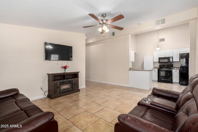 511 E Purdue Ave, Phoenix, AZ 85020 - living area featuring ceiling fan, baseboards, light tile patterned floors, and a glass covered fireplace