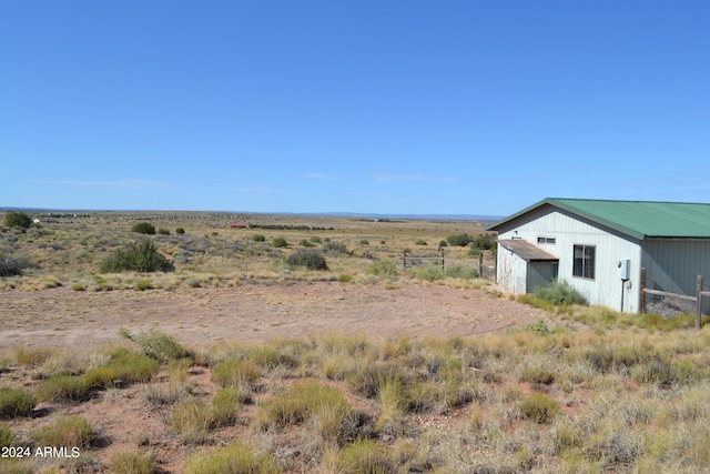 view of yard featuring a rural view and an outbuilding