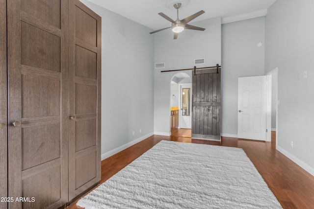 bedroom featuring visible vents, dark wood finished floors, and a towering ceiling