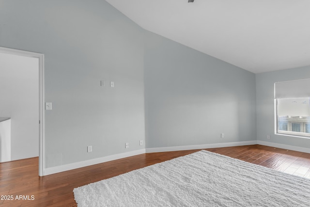 spare room with baseboards, visible vents, wood finished floors, and lofted ceiling