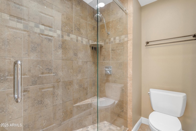 full bath featuring toilet, baseboards, and a stall shower