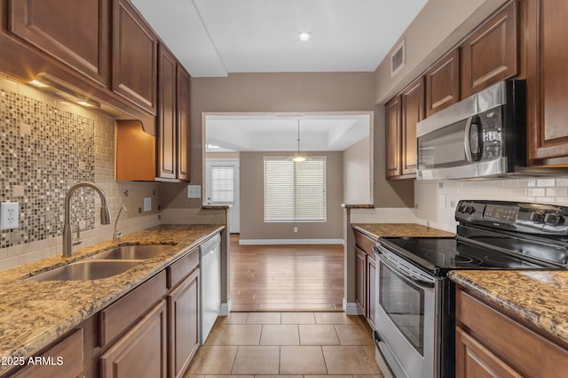 kitchen featuring stainless steel appliances, visible vents, decorative backsplash, and a sink