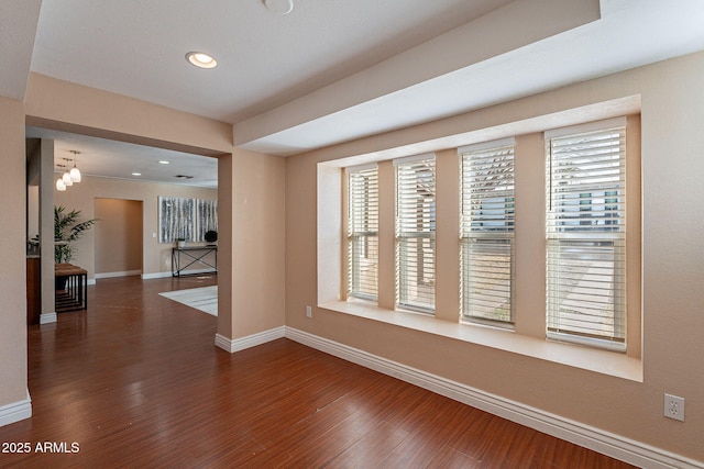 empty room with recessed lighting, dark wood-style flooring, plenty of natural light, and baseboards