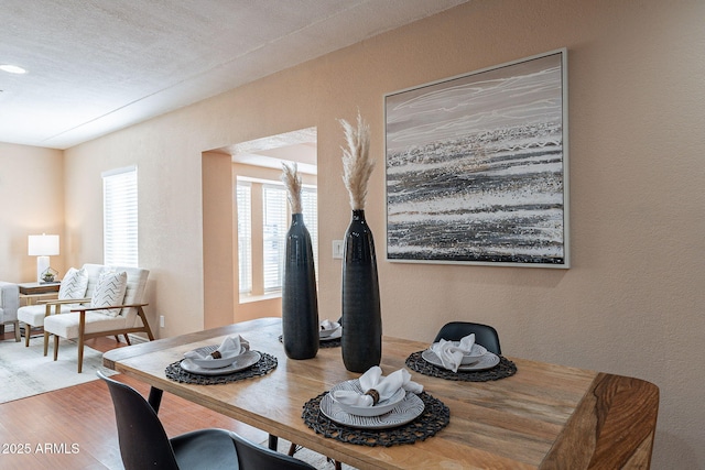 dining room featuring wood finished floors and a textured wall