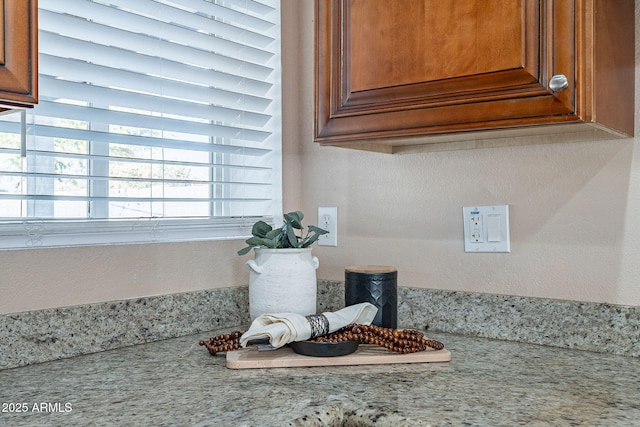 room details with light stone counters and brown cabinetry