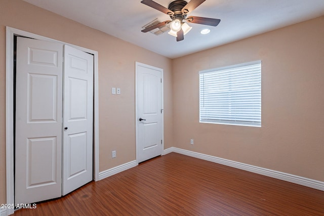 unfurnished bedroom with a ceiling fan, a closet, baseboards, and wood finished floors