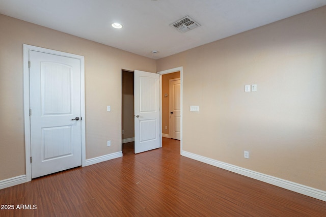 unfurnished bedroom featuring recessed lighting, wood finished floors, visible vents, and baseboards