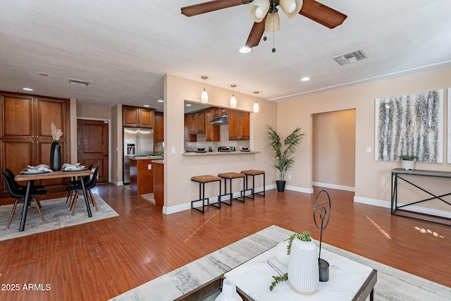 living room with visible vents, baseboards, and wood finished floors