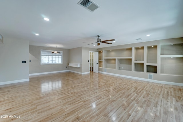 unfurnished living room featuring ceiling fan, light wood-type flooring, and built in shelves