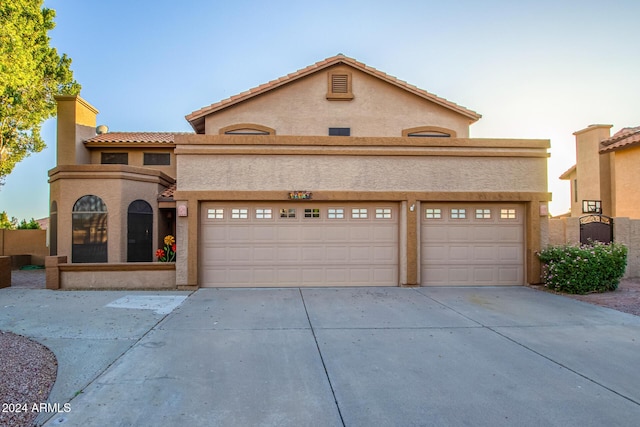 13128 N 104th Pl, Scottsdale, AZ 85260 - mediterranean / spanish-style house featuring concrete driveway, stucco siding, an attached garage, and a tile roof
