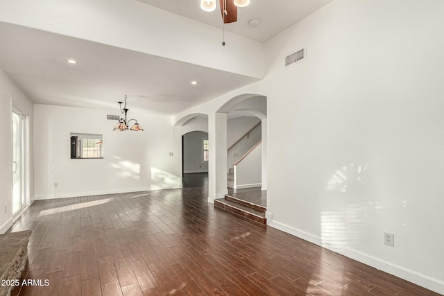 13128 N 104th Pl, Scottsdale, AZ 85260 - spare room with arched walkways, dark wood-style flooring, baseboards, a ceiling fan, and stairs