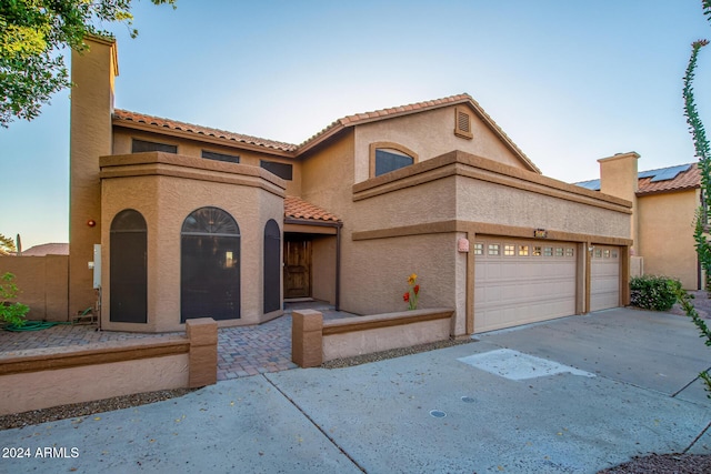 13128 N 104th Pl, Scottsdale, AZ 85260 - mediterranean / spanish-style house featuring a tiled roof, stucco siding, concrete driveway, and a garage