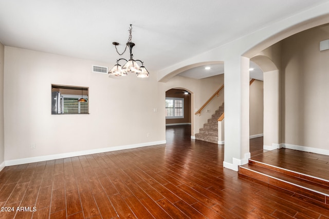 empty room featuring dark hardwood / wood-style floors and a chandelier