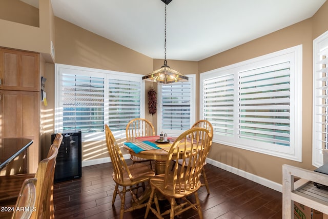 dining area featuring vaulted ceiling, dark wood-type flooring, and beverage cooler