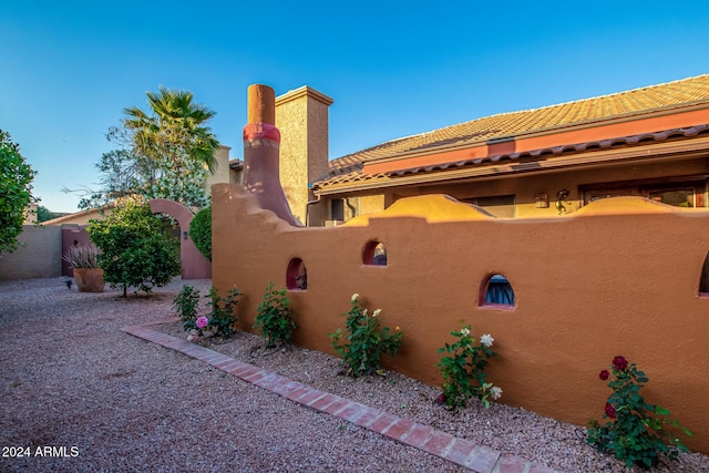 13128 N 104th Pl, Scottsdale, AZ 85260 - view of side of property featuring a tiled roof, stucco siding, and a chimney