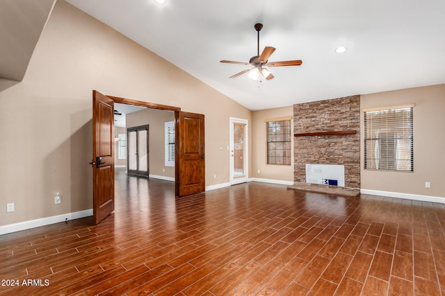 unfurnished living room featuring a healthy amount of sunlight, a stone fireplace, dark hardwood / wood-style floors, and ceiling fan