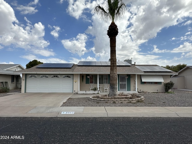 ranch-style house featuring a garage and solar panels