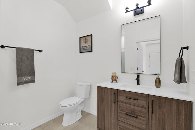 bathroom with vanity, toilet, and lofted ceiling