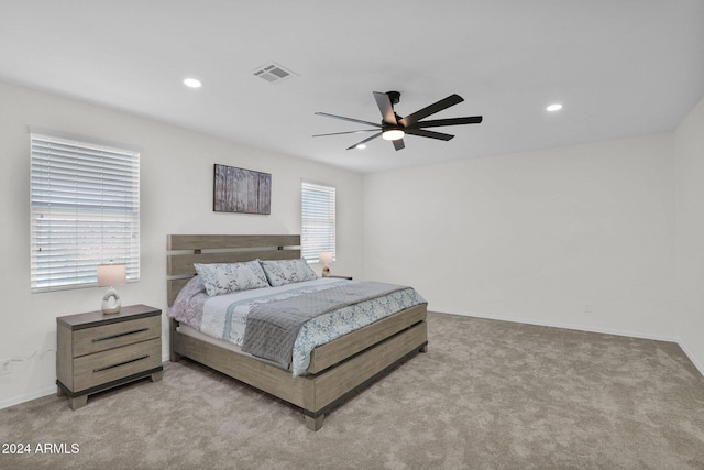 carpeted bedroom featuring multiple windows and ceiling fan