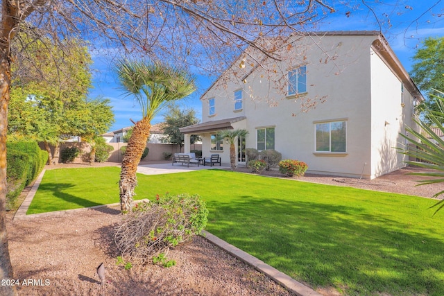 back of house featuring a patio and a lawn