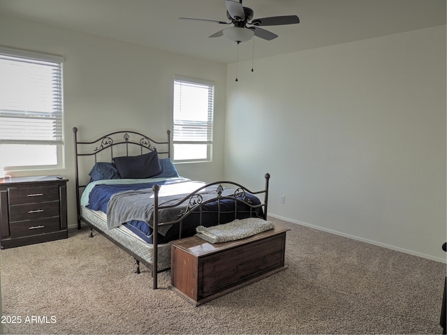 carpeted bedroom featuring ceiling fan and multiple windows