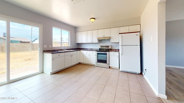 kitchen with sink, white cabinets, white fridge, light tile patterned floors, and electric range