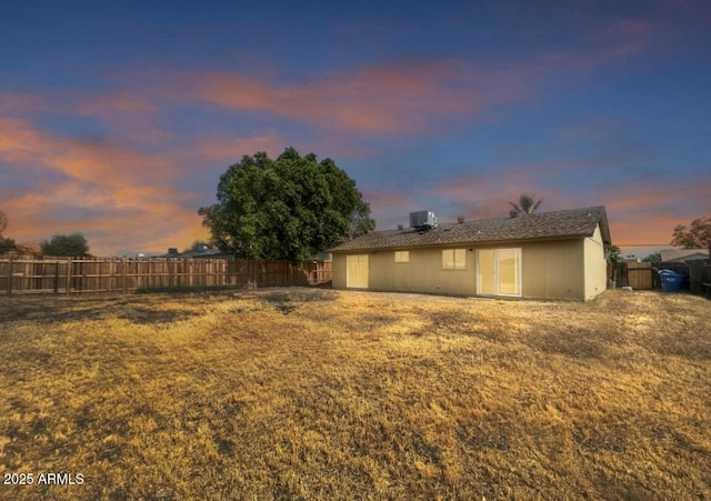 yard at dusk featuring central AC unit