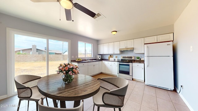 kitchen with light tile patterned flooring, white cabinets, stainless steel range with electric stovetop, white refrigerator, and ceiling fan