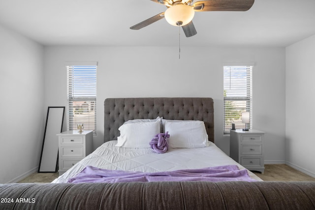 bedroom featuring a ceiling fan, light colored carpet, and baseboards