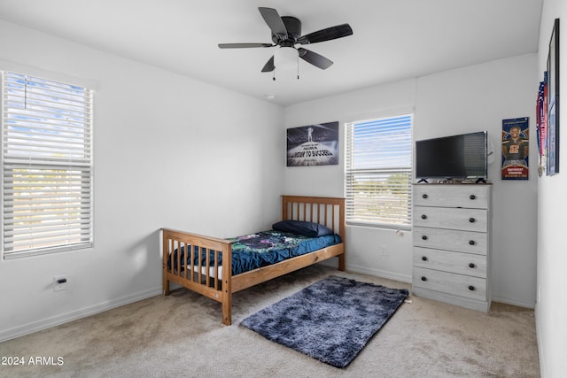 carpeted bedroom with baseboards and a ceiling fan