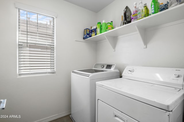 clothes washing area featuring laundry area, washing machine and dryer, and baseboards